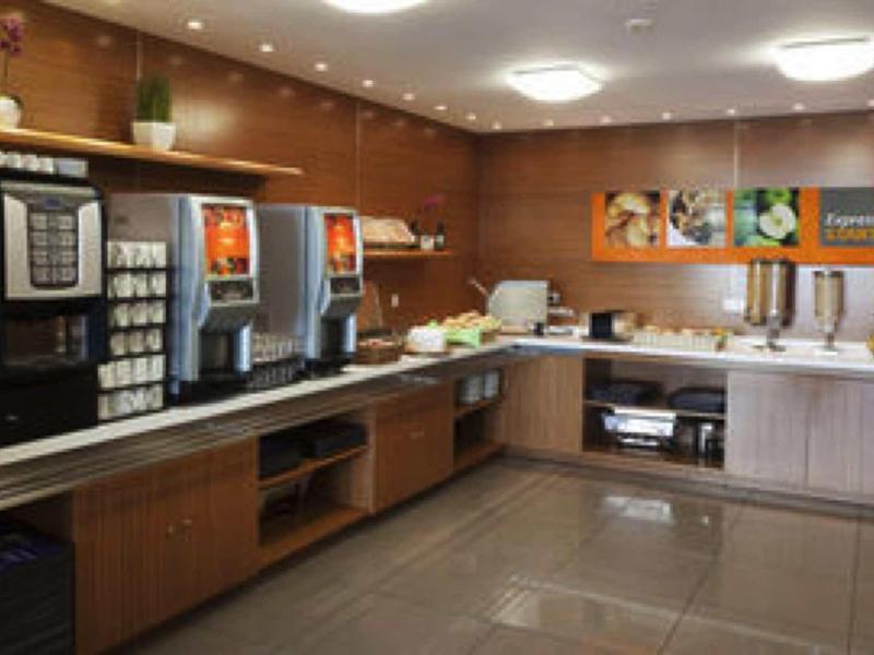 Cucina moderna dell'hotel con macchine per il caffè e snack su lunghe superfici.