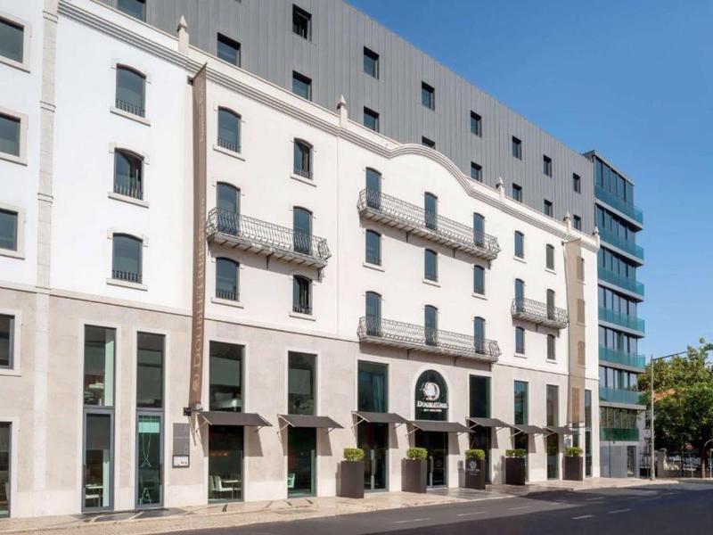 Edificio moderno di un hotel con facciate bianche e grigie su una strada tranquilla.