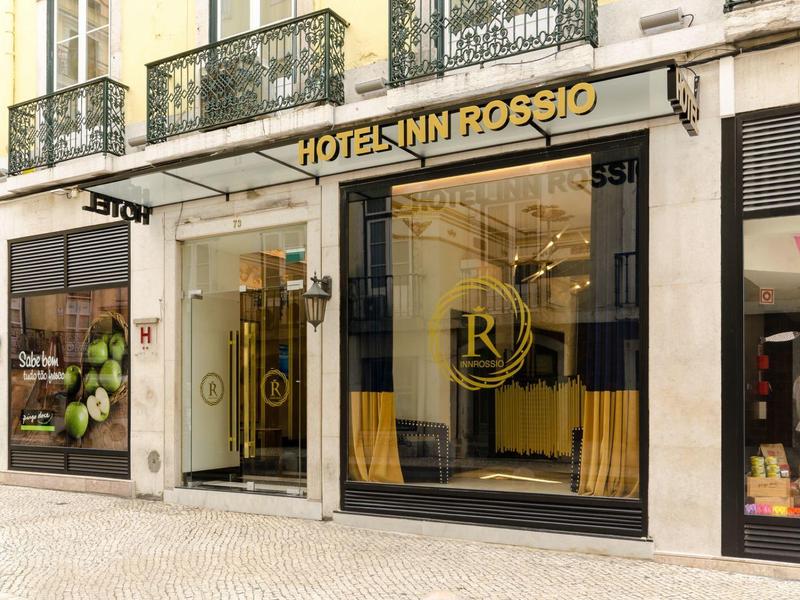 Ingresso dell'Hotel Inn Rossio con facciata in vetro e accenti dorati in città