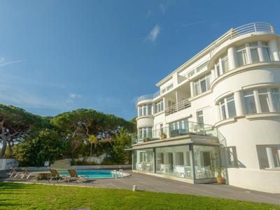 Edificio di hotel bianco moderno con piscina e lettini in giardino soleggiato