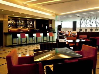 Modern eingerichtete Hotelbar mit Sitzgelegenheiten und Stuhlreihen an der Bar