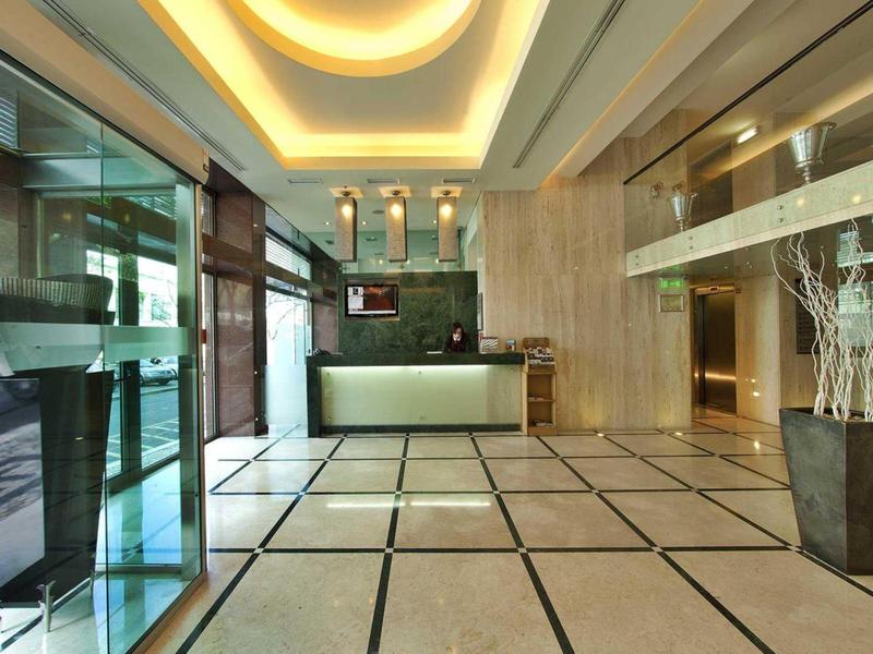 Moderna hall dell'hotel con luce brillante, reception e grande pavimento in marmo.