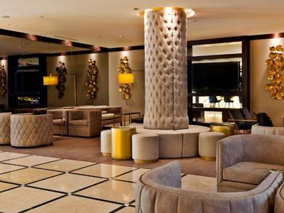 Elegant hotel lobby with gray armchairs, column, and warm lighting