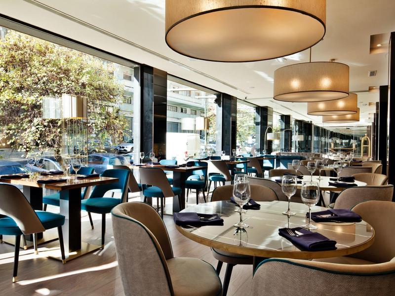 Ristorante moderno con tavoli eleganti e grandi finestre con vista sulla strada.