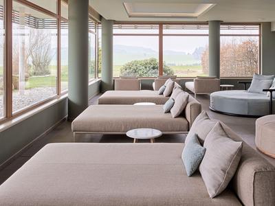 Modernes Hotelzimmer mit großen Fenstern, mehreren Sofabetten und minimalistischer Einrichtung.