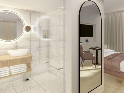 Modernes Badezimmer mit beleuchtetem Spiegel, Waschbecken, Handtüchern und Blick ins Schlafzimmer.