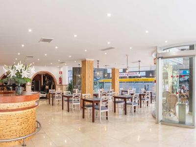 Area lobby dell'hotel moderna e luminosa con banco reception e posti a sedere.