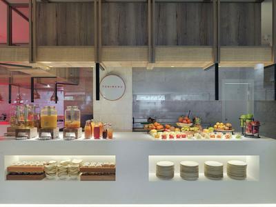 Area buffet con succhi, frutta e piatti in un ristorante d'albergo moderno.