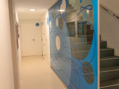 Corridoio luminoso con moderna parete blu accanto a una scala in un hotel.