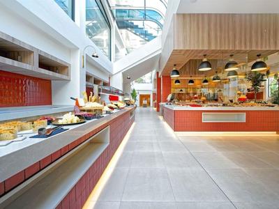 Jasna strefa samoobsługowa hotelu z bufetem i nowoczesnym designem.