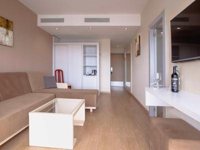 Moderner Wohnraum mit braunem Sofa, hellem Holzboden und weißem Couchtisch in langem Raum.