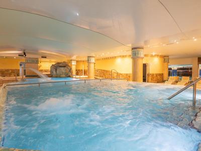 Moderner Innenpool mit Whirlpool und warmem Lichtambiente in einem Hotel.