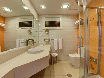 Bagno moderno con lavabo, WC, doccia in vetro e grandi specchi.