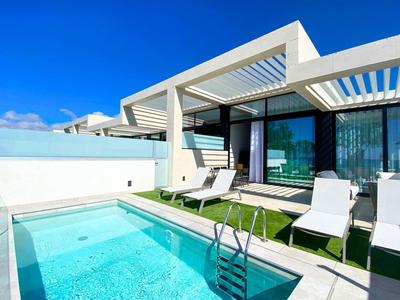 Nowoczesny taras hotelowy z basenem, leżakami i czystym niebieskim niebem