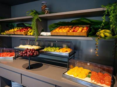 Kolorowy bufet śniadaniowy z różnymi świeżymi owocami na nowoczesnej półce.