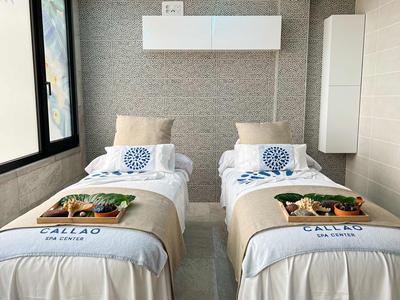 Dwa nowoczesne łóżka pojedyncze w jasnym pokoju hotelowym z oknem i elementami dekoracyjnymi.