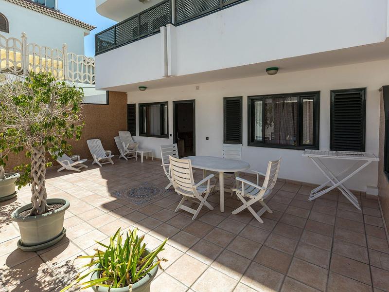 Jasny taras z miejscami do siedzenia i roślinami w hotelu.