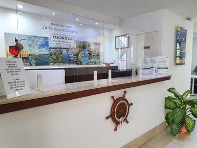 Empfangstresen eines Hotels mit maritimer Dekoration und Informationsmaterial.