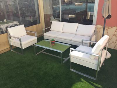 Moderní lounge s posezením a stolem na umělé trávě