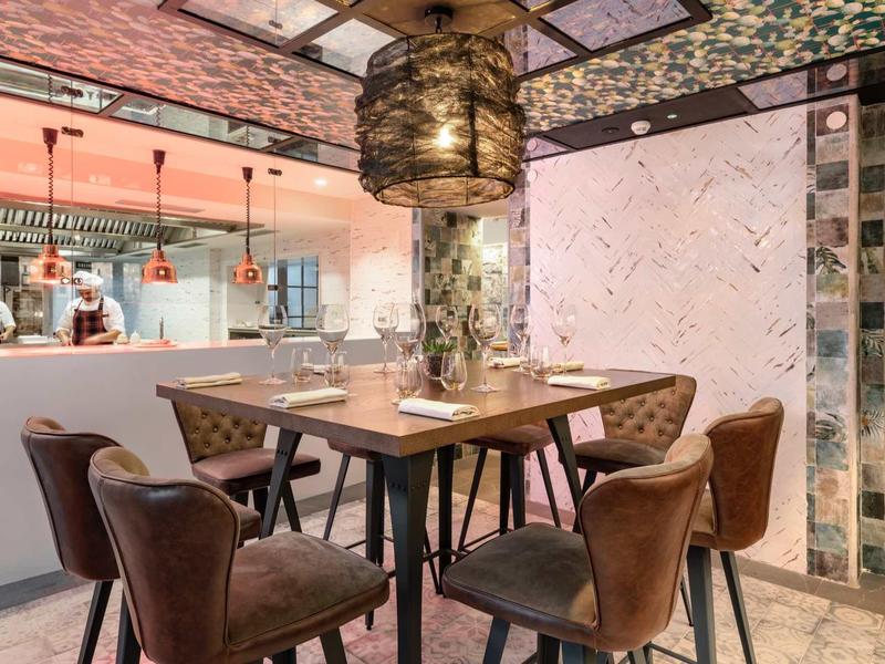 Elegancka jadalnia hotelowa z meblami z aksamitu i kwiatowymi dekoracjami na suficie.