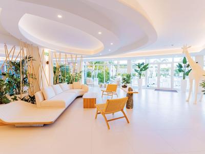 Hellichte en moderne hotellobby met zithoeken en grote glazen ramen.