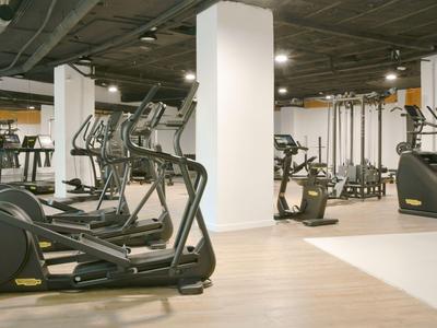 Moderne fitnessruimte met loopbanden en fitnessapparaten in een hotel.