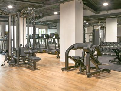 Moderne fitnessruimte met oefenapparatuur en halters in een hotel