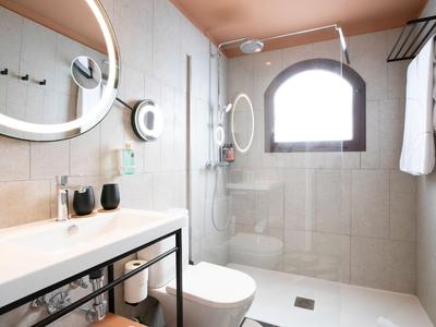 Modern bathroom with shower cabin, sink, and large window.