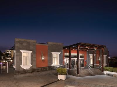 Modern hotel restaurant with outdoor area and ambient lighting at night.