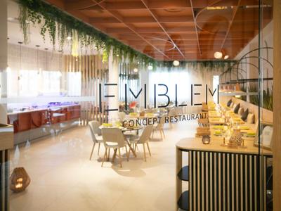 Modern hotel restaurant with wooden ceiling, green plants, and inviting seating area.