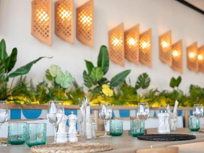 Elegant restaurant table with modern lamps and green plants on the wall.