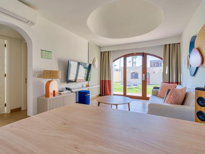 Cozy hotel room with large arched window and modern interior.