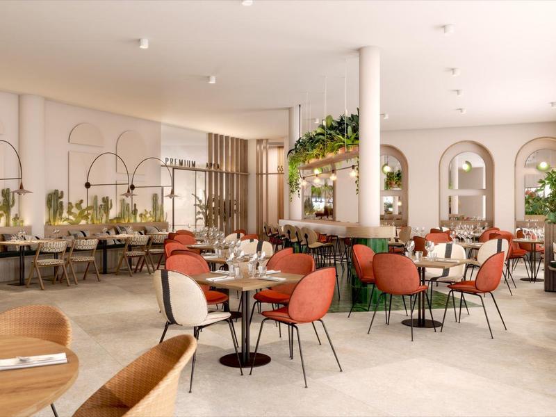 Bright, modern restaurant with colorful chairs, large windows, and plants as decoration.