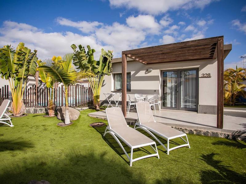 House with terrace and sun loungers in the garden on a sunny day.