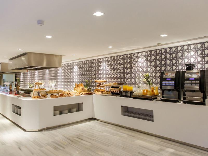 Buffet moderne avec viennoiseries et boissons, décor élégant et lumière douce.