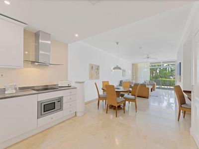 Helle, moderne Küche mit Essbereich und großen Fenstern, die Tageslicht hereinlassen.