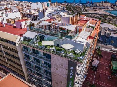 Mehrstöckiges Wohngebäude mit begrüntem Dach und Balkonterrassen in dichter Stadtszenerie.