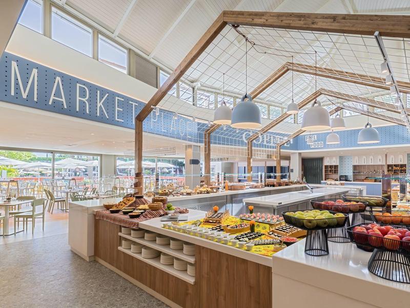 Bright buffet station in modern dining area with diverse selection of fruits and bread.