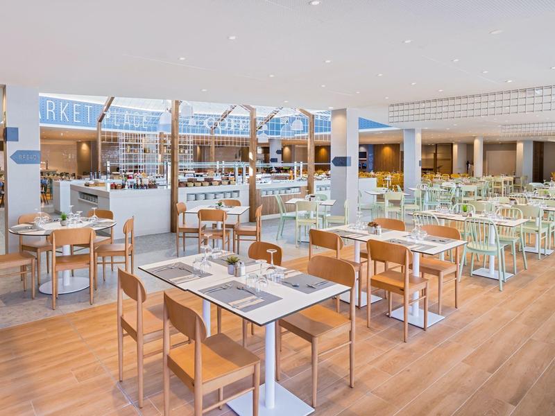 Bright, modern restaurant with wooden floor, seating areas, and buffet counters.