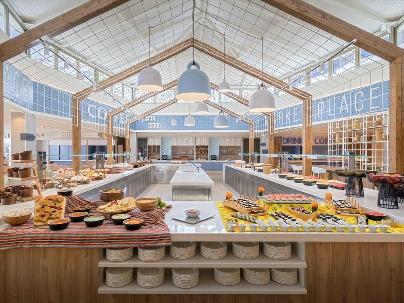 Large modern breakfast area with long buffet and wooden frame ceiling.