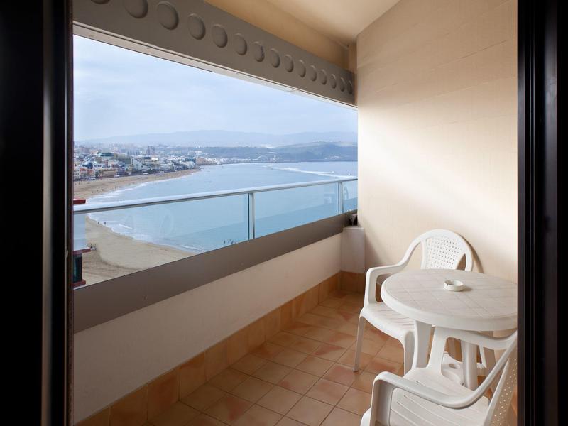 Balcone con due sedie bianche e tavolo con vista sul mare e sulla costa.