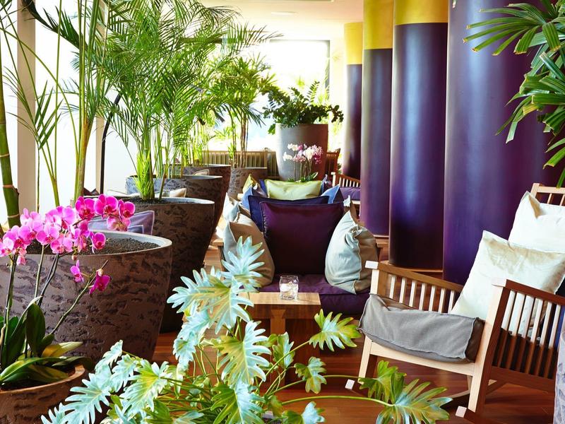 Terrazza accogliente con piante e mobili da seduta in luce calda.