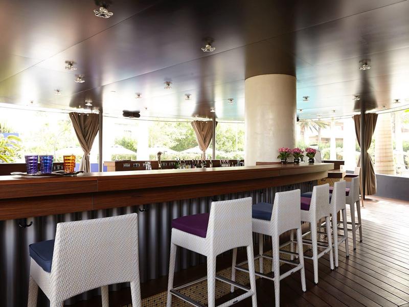 Bar dell'hotel elegante con sedute bianche e vista sulla terrazza.