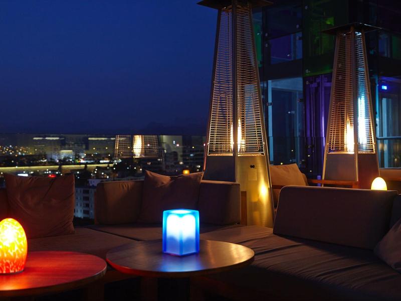 Accogliente lounge dell'hotel di notte con luci colorate e vista sulla città.