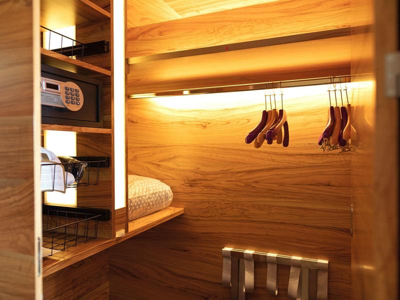 Armadio in legno con ripiani, illuminato e dotato di appendini e cassaforte