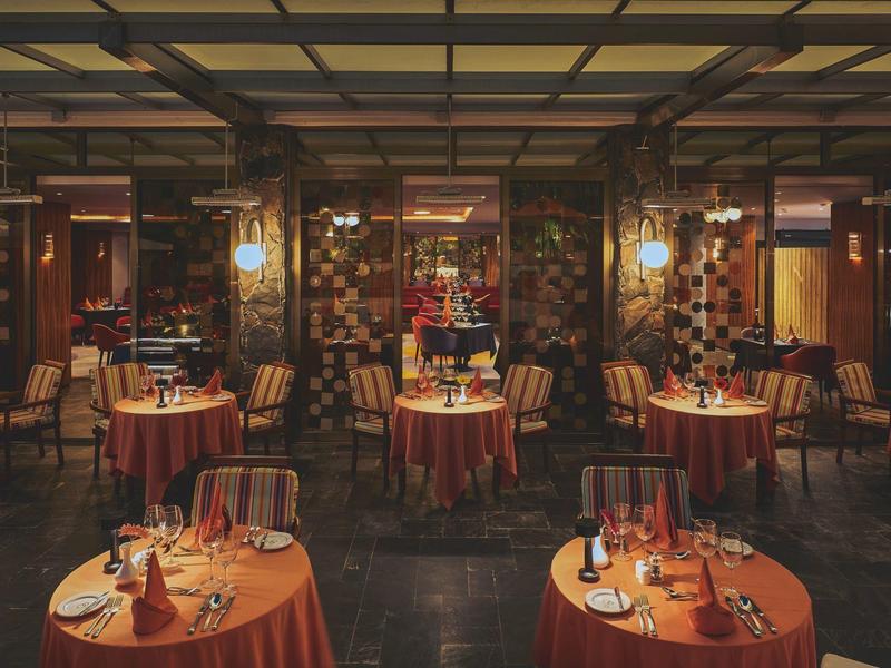 Restaurante elegante con mesas redondas y luz cálida, ideal para una noche romántica.