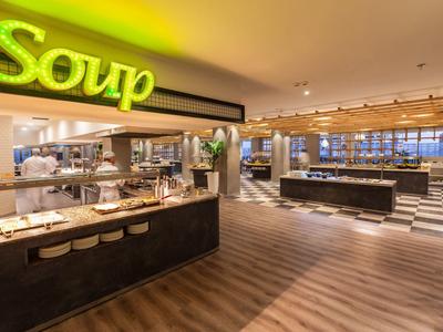 Großer, heller Speisesaal mit modernen Buffetstationen und beleuchtetem "Soup"-Schild.