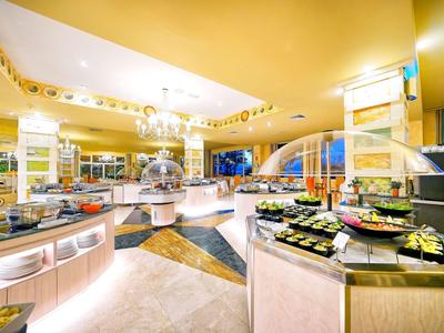 Ristorante a buffet luminoso con banchi rotondi e varie opzioni alimentari sotto luce calda.