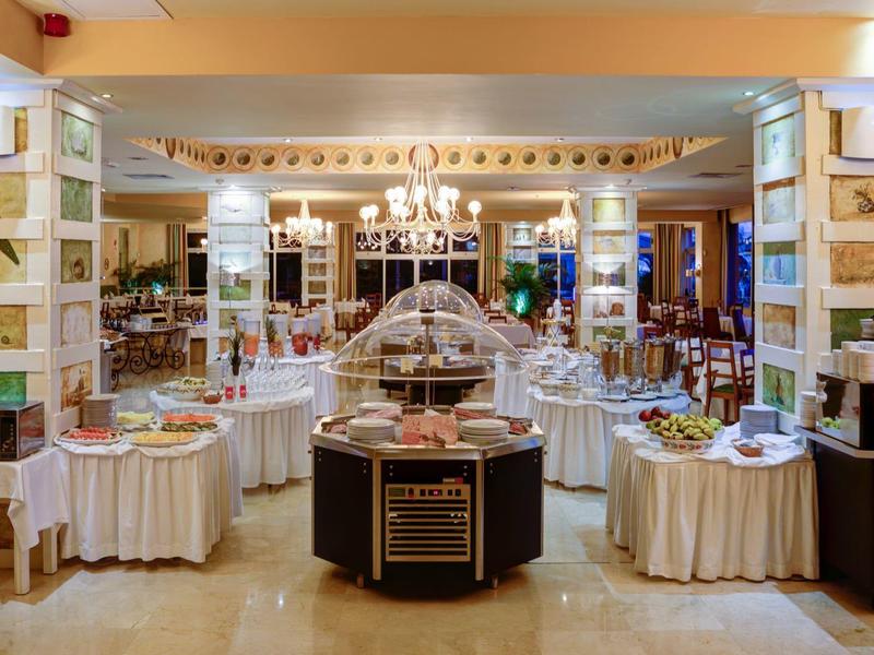 Luxe buffetopstelling met elegante verlichting en diverse voedselpresentaties in een ruime eetzaal.