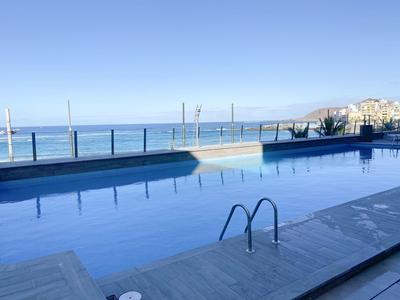 Piscine avec vue sur l'océan et balustrade par une journée ensoleillée à l'hôtel